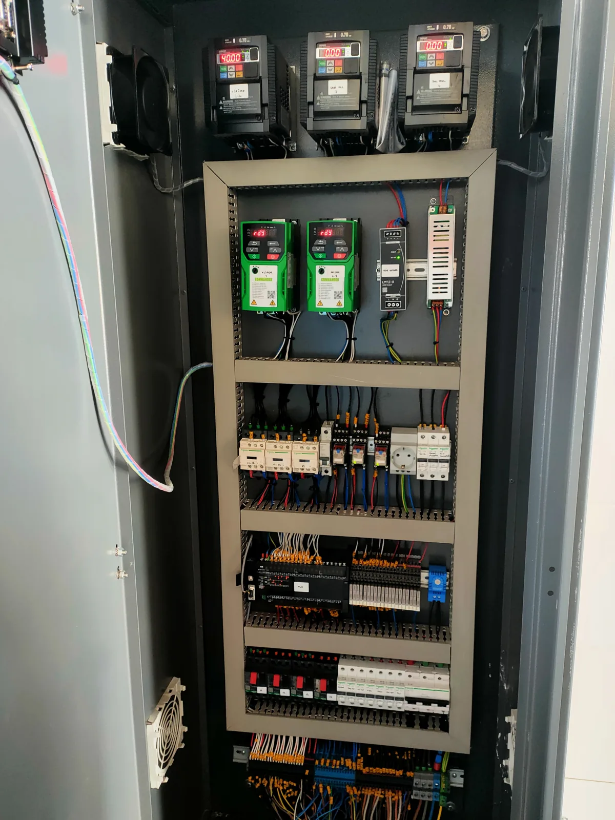 An open electrical control cabinet with wiring and components inside